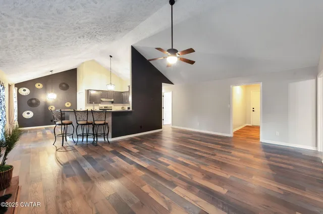 a view of a livingroom with furniture wooden floor and a chandelier