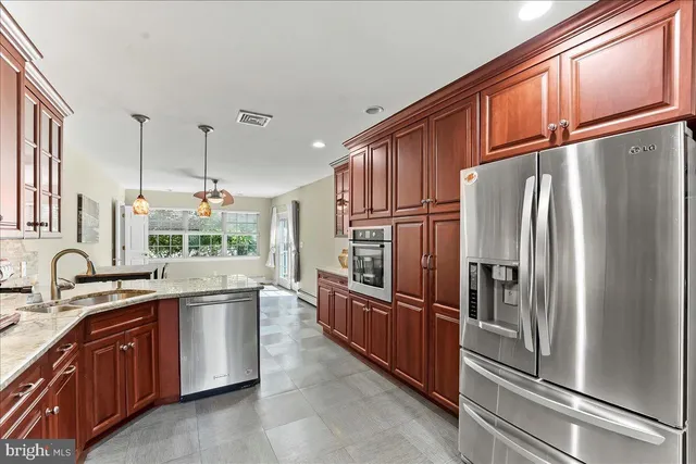 a kitchen with stainless steel appliances granite countertop a refrigerator stove and sink