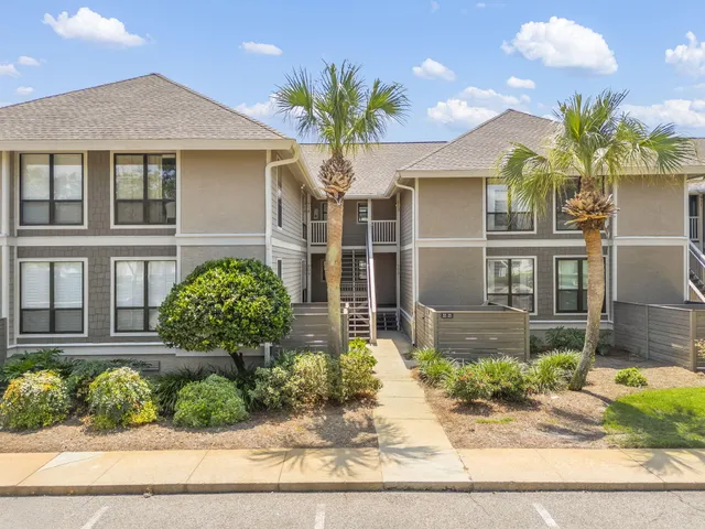 a front view of a house with a yard and potted plants