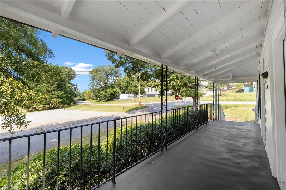 201 South 8th Street Easley, SC 29640 - Photo 4 of 28 An inviting covered porch features a vaulted beamed ceiling and durable concrete flooring.