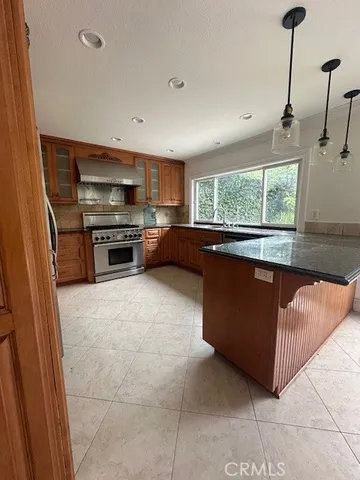 a kitchen with stainless steel appliances granite countertop a refrigerator and a stove