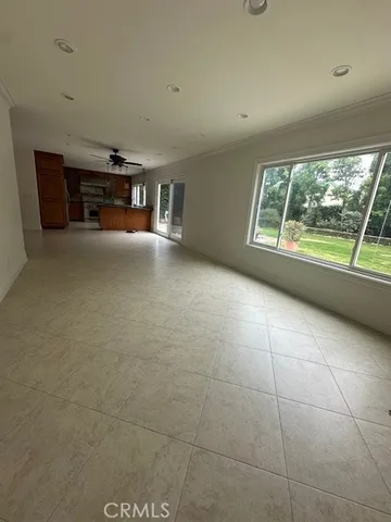 a view of empty room with floor to ceiling window and fireplace