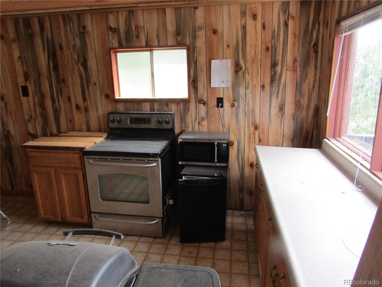 676 Gross Road Bailey, CO 80421 - Photo 13 of 18 a kitchen with wooden cabinets and a stove top oven