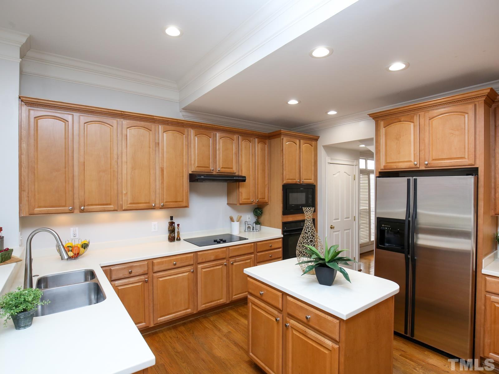 3905 Bentley Meadow Lane Raleigh, NC 27612 - Photo 15 of 40 a kitchen with refrigerator cabinets and a sink
