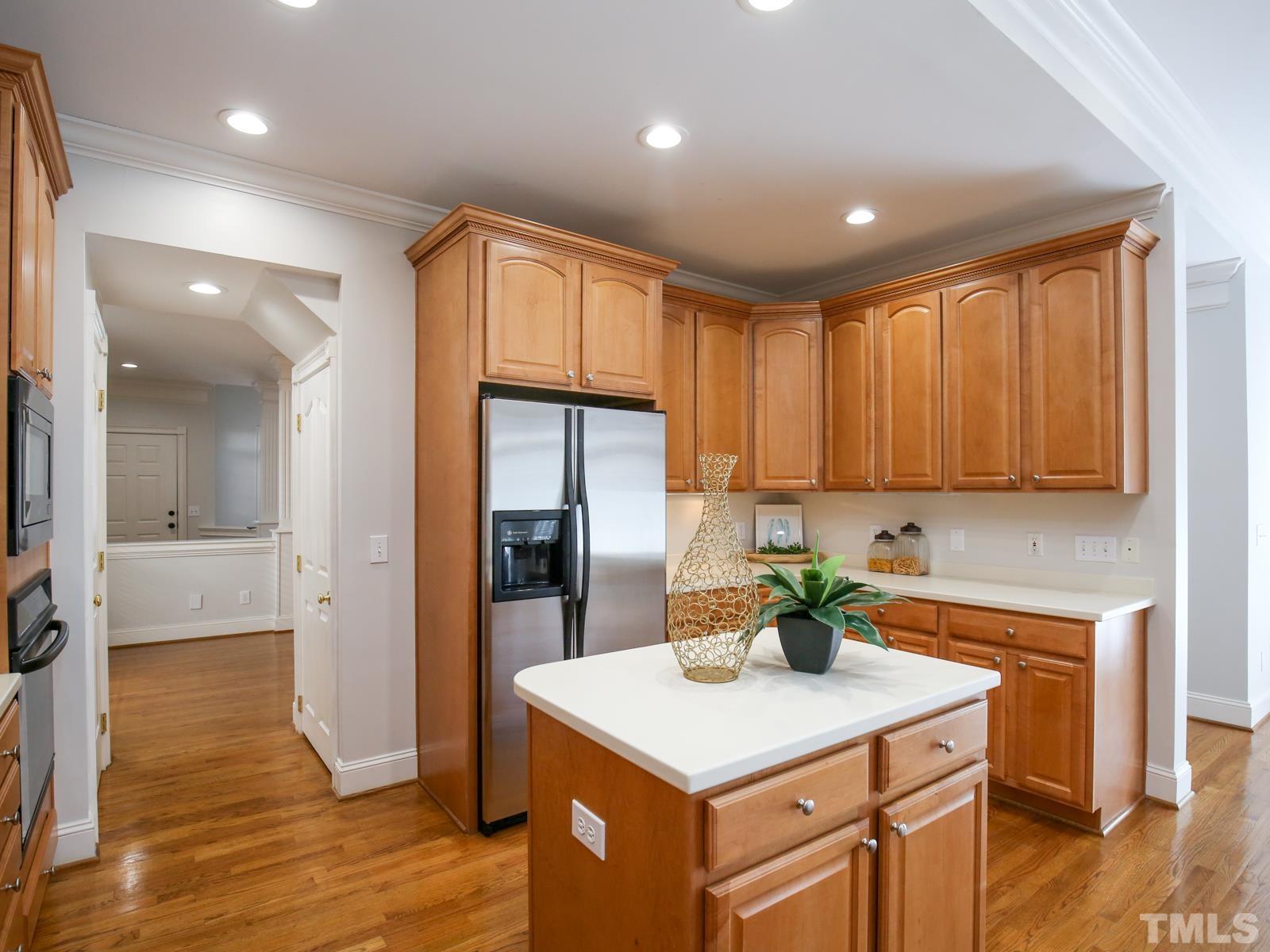 3905 Bentley Meadow Lane Raleigh, NC 27612 - Photo 19 of 40 a kitchen with a sink a refrigerator and cabinets