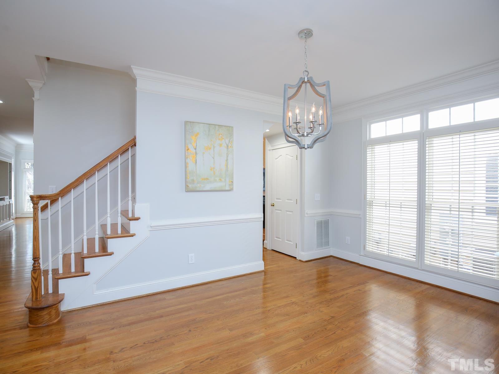 3905 Bentley Meadow Lane Raleigh, NC 27612 - Photo 4 of 40 a view of an empty room with wooden floor and a window