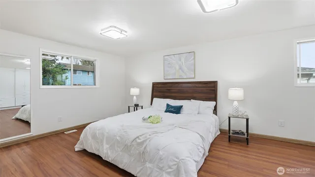 a bedroom with a bed and wooden floor