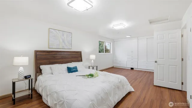 a bedroom with a bed and wooden floor