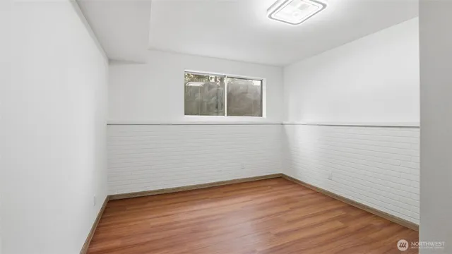 a view of a small space with wooden floor and a window