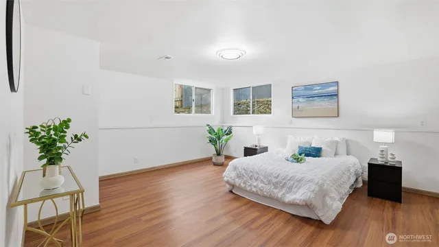a bedroom with a bed wall painting and wooden floor