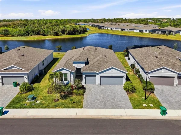 an aerial view of a house with a garden and lake view