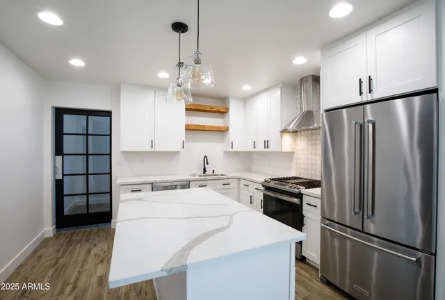 a kitchen with stainless steel appliances a refrigerator sink and stove