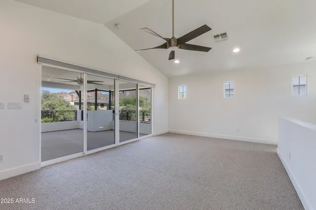 an empty room with windows and fan