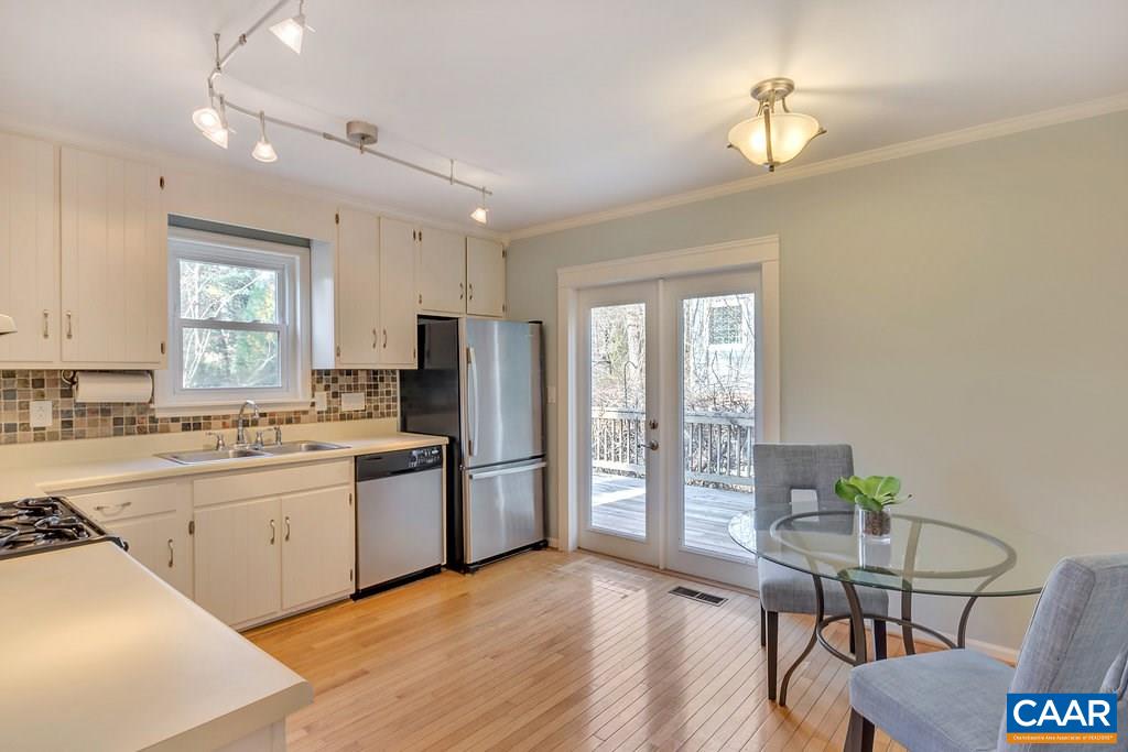 304 North Bennington Road Charlottesville, VA 22901 - Photo 10 of 37 a kitchen with stainless steel appliances granite countertop a stove a refrigerator a sink dishwasher a dining table and chairs with wooden floor