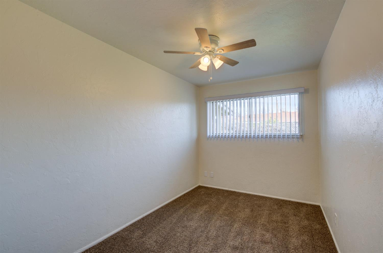 3955 North Tollhouse Road Fresno, CA 93726 - Photo 12 of 17 an empty room with windows and fan