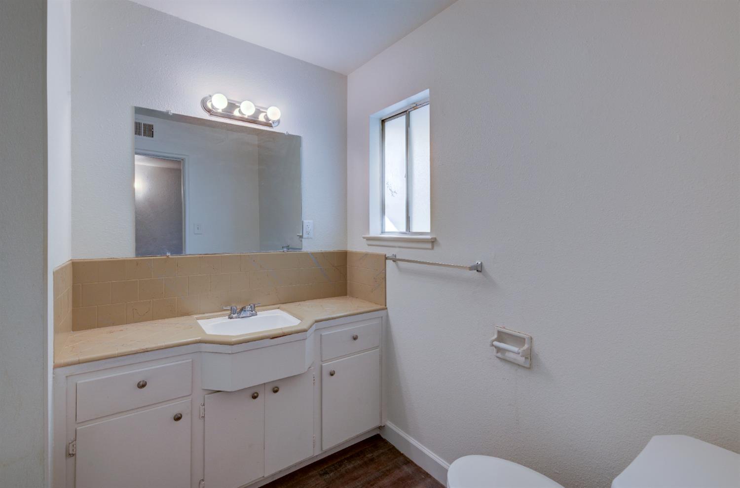 3955 North Tollhouse Road Fresno, CA 93726 - Photo 13 of 17 a bathroom with a sink toilet and mirror