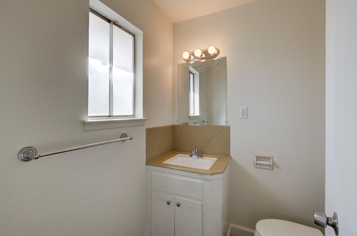 3955 North Tollhouse Road Fresno, CA 93726 - Photo 14 of 17 a bathroom with a sink a toilet and a mirror