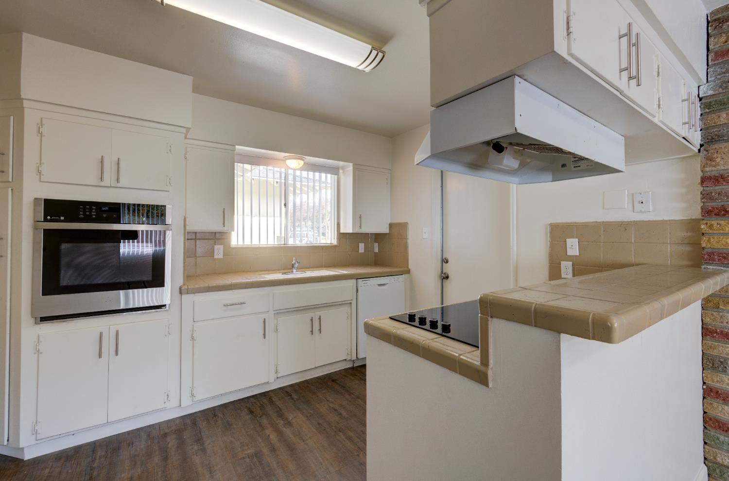 3955 North Tollhouse Road Fresno, CA 93726 - Photo 7 of 17 a kitchen that has a sink and a stove