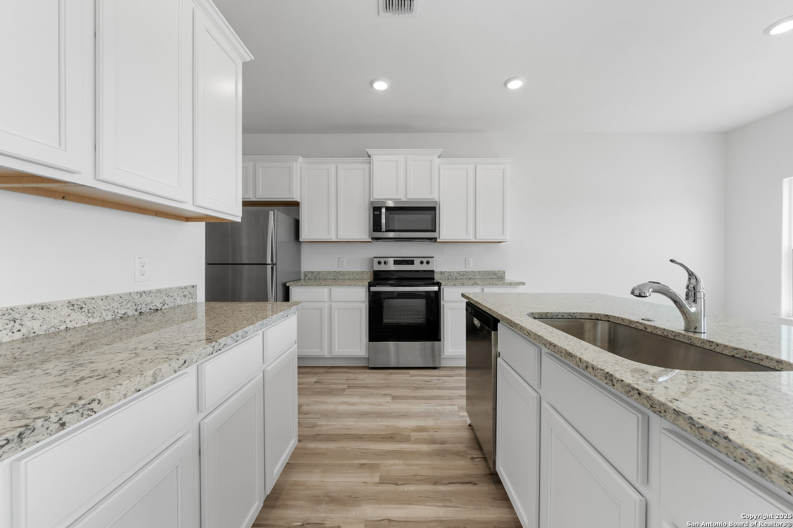 16020 Stratford Cove Lytle, TX 78052 - Photo 11 of 29 a kitchen with granite countertop white cabinets and stainless steel appliances