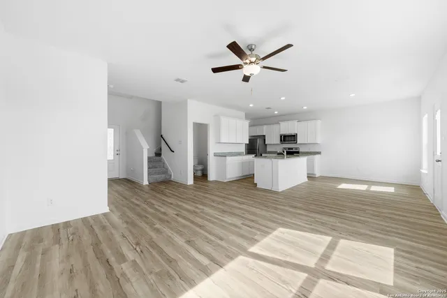 a view of a kitchen with wooden floor and a sink