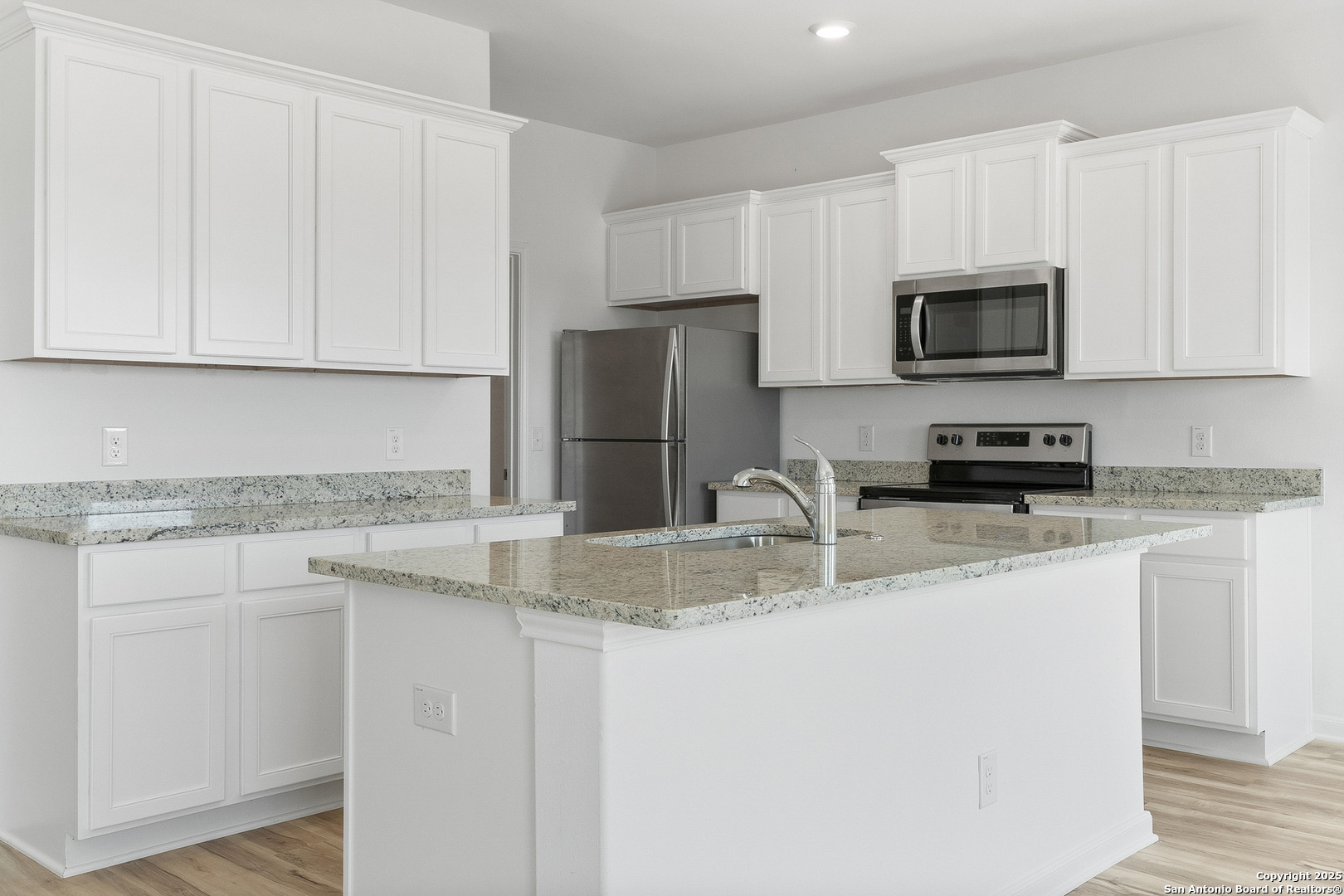 16020 Stratford Cove Lytle, TX 78052 - Photo 7 of 29 a kitchen with stainless steel appliances granite countertop a sink a stove a microwave and a refrigerator