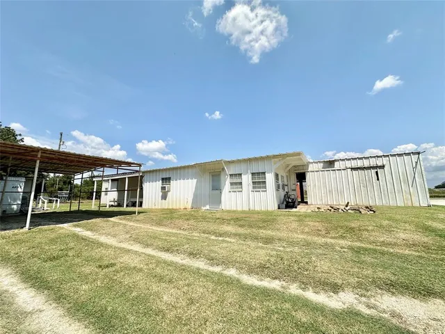 a view of a house with a big yard and large trees