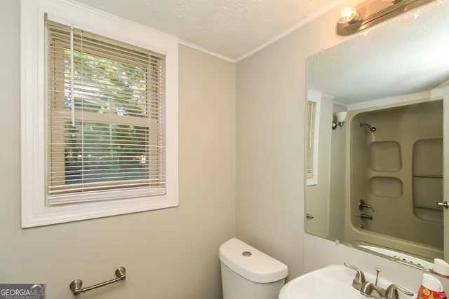 a bathroom with a toilet a sink and shower