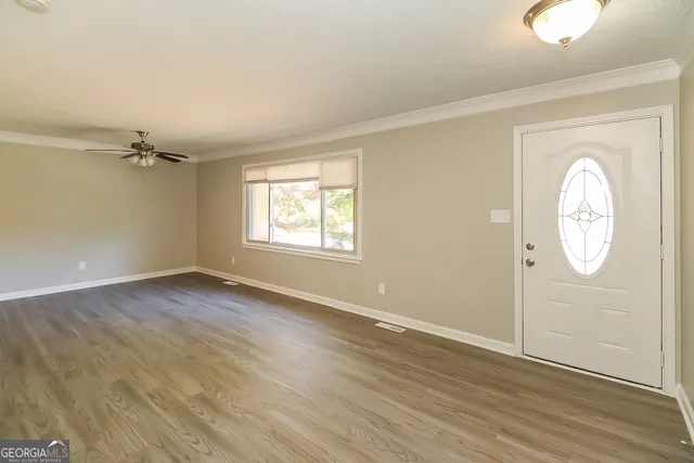 a view of empty room with wooden floor