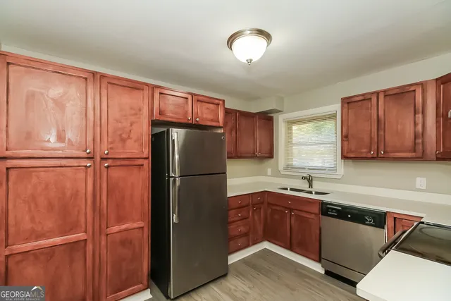 a kitchen with a refrigerator sink and cabinets