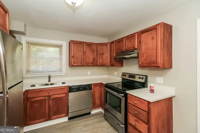 a kitchen with stainless steel appliances granite countertop a sink stove and cabinets