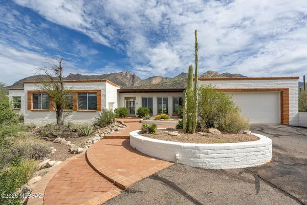 a view of a house with backyard fountain and sitting area