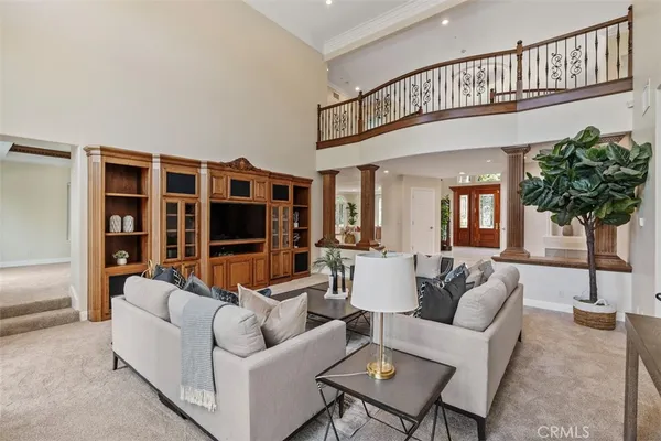 a living room with furniture a chandelier and a flat screen tv