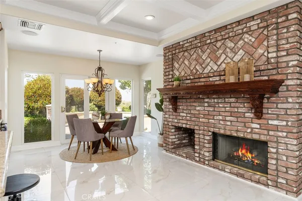a dining room with furniture a fireplace and a large window
