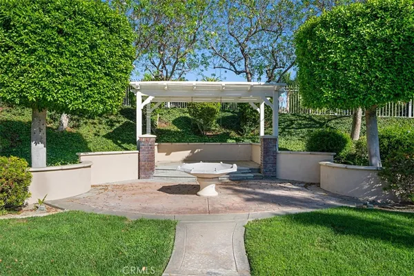 a view of a patio with table and chairs potted plants and a large tree
