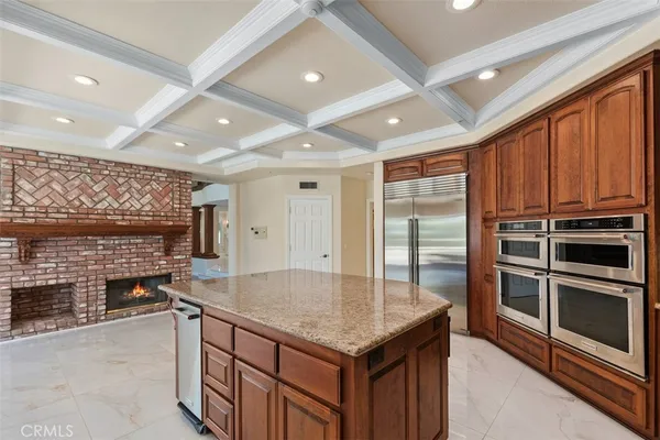 a kitchen with kitchen island a counter top space a sink stainless steel appliances and cabinets