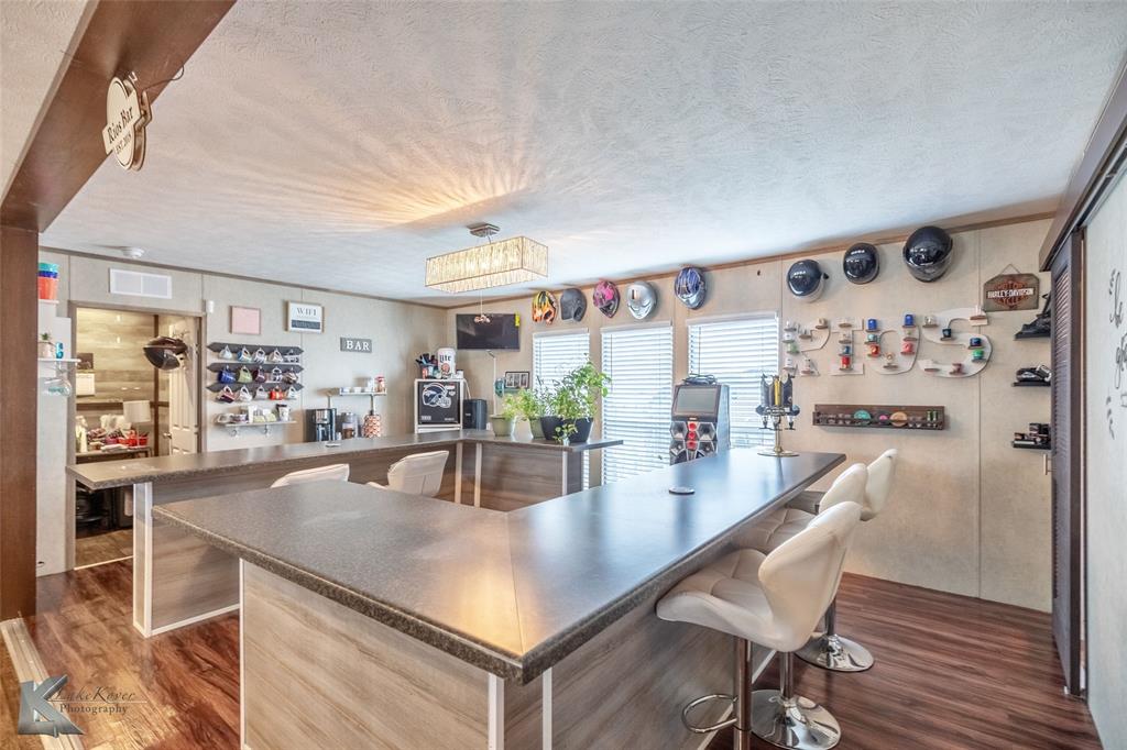 1301 Roma Lane Abilene, TX 79603 - Photo 6 of 20 Indoor dry bar with dark wood-type flooring and a textured ceiling