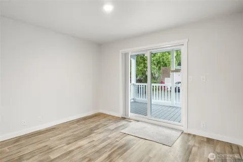an empty room with wooden floor and a floor to ceiling window