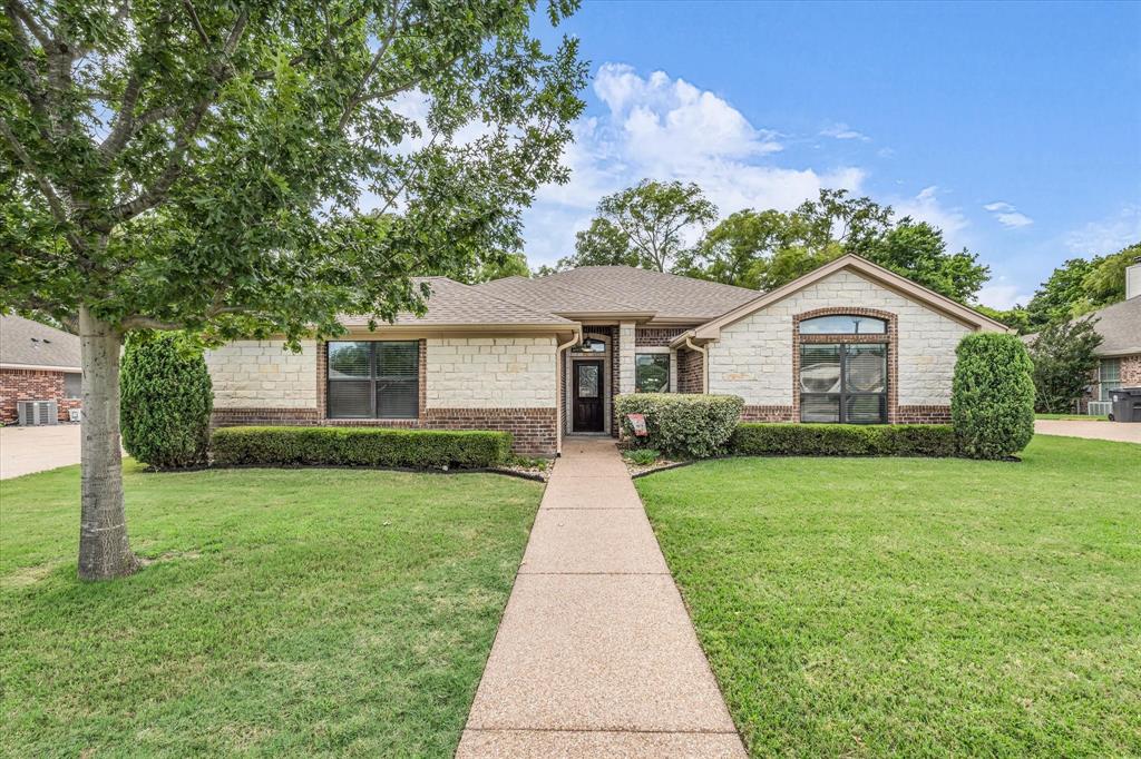 814 Springdale Circle Lorena, TX 76655 - Photo 1 of 37 Stone and brick facade home featuring a gabled roofline, arched window detail, established shrubbery, and a concrete walkway