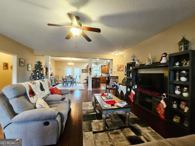a living room with furniture kitchen view and a chandelier