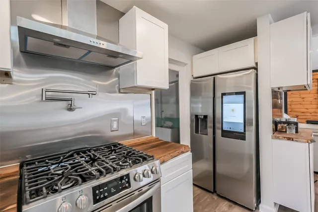 a kitchen with stainless steel appliances granite countertop a refrigerator and a stove