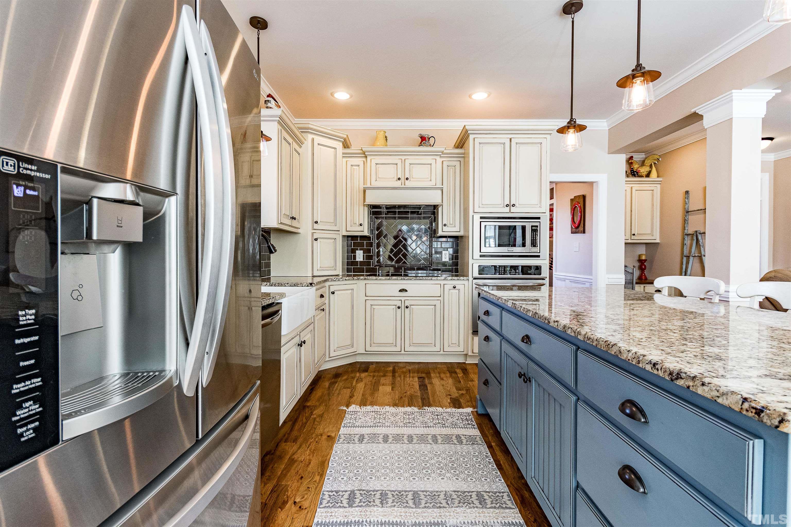 4300 Debnam Road Zebulon, NC 27597 - Photo 25 of 54 a large kitchen with stainless steel appliances kitchen island granite countertop a refrigerator and a sink
