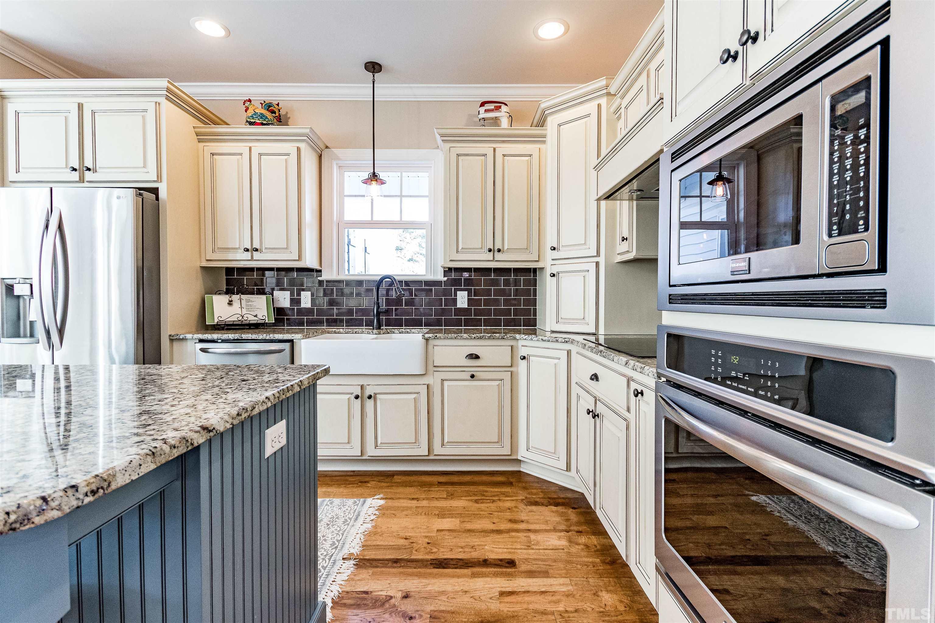 4300 Debnam Road Zebulon, NC 27597 - Photo 27 of 54 a kitchen with stainless steel appliances granite countertop a stove a sink and a refrigerator