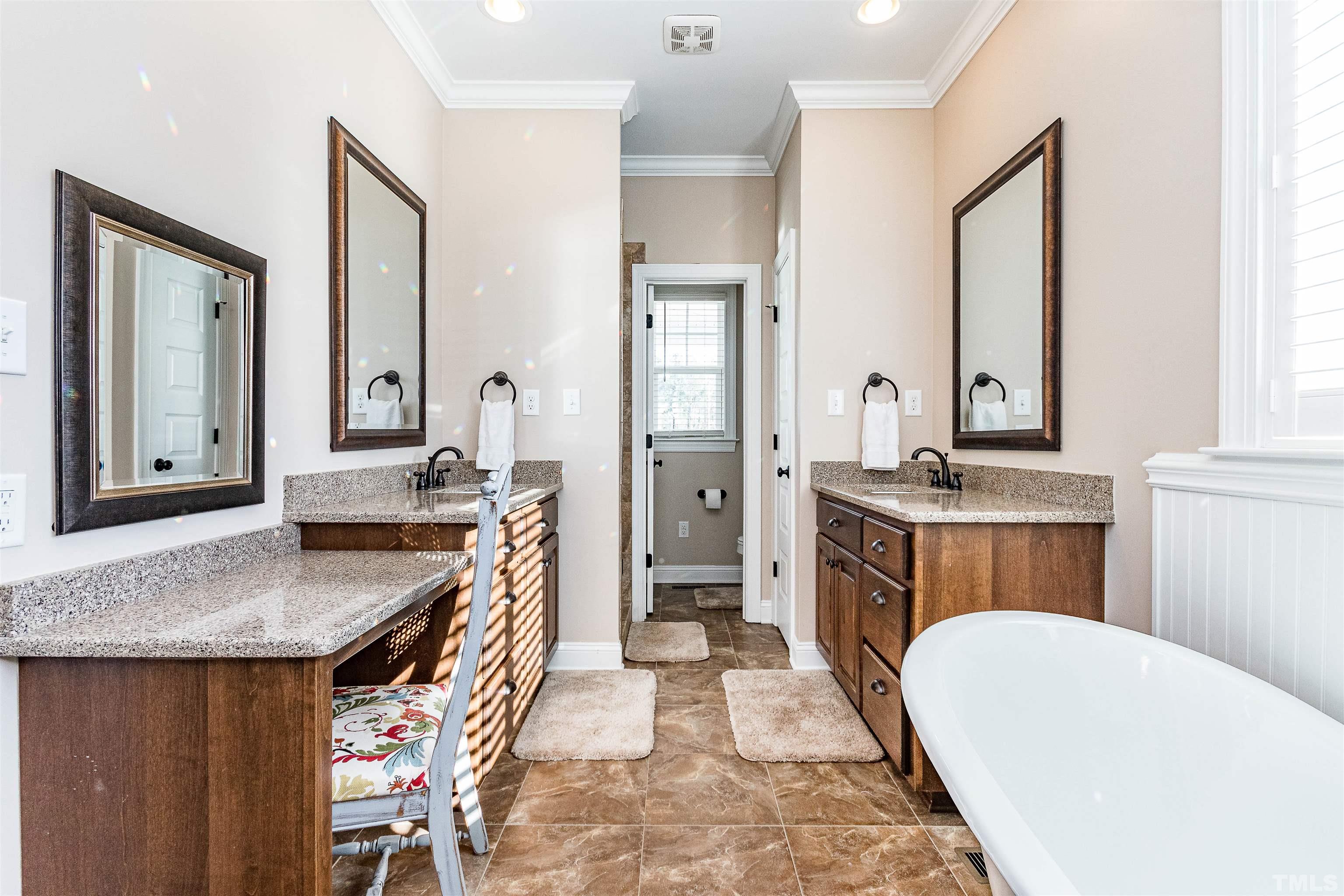 4300 Debnam Road Zebulon, NC 27597 - Photo 43 of 54 a bathroom with a granite countertop sink a mirror a vanity and a bathtub