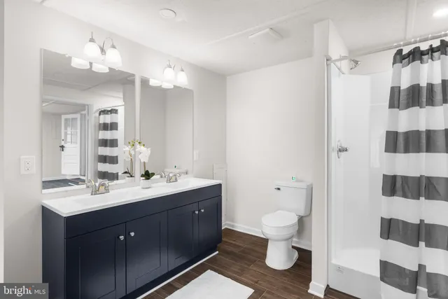 a bathroom with a sink a toilet a shower and a mirror