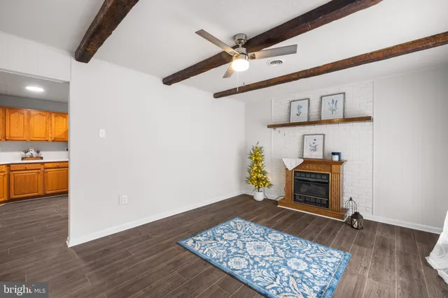 a living room with stainless steel appliances furniture a rug and a fireplace