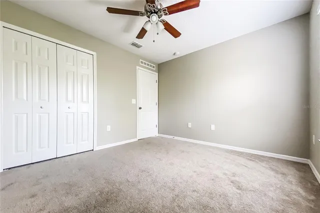 an empty room with chandelier fan