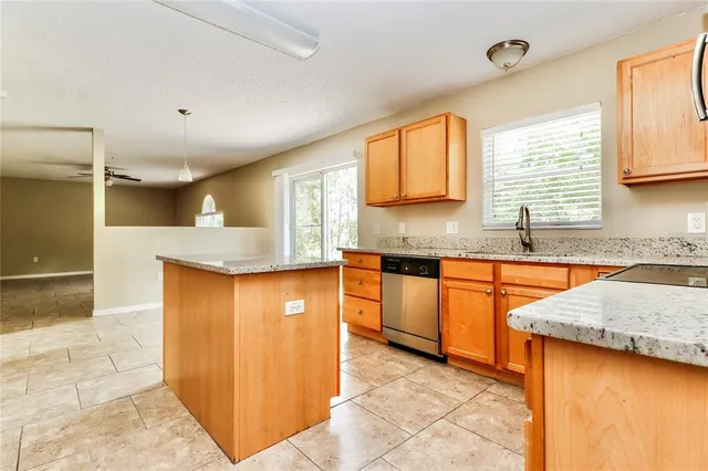 a kitchen with stainless steel appliances granite countertop a sink and a stove