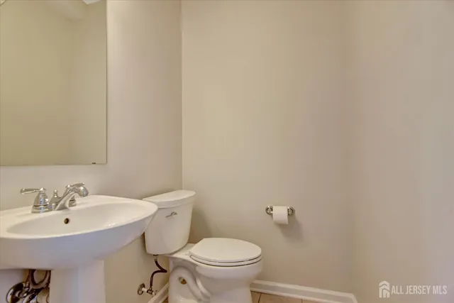 a bathroom with a sink a toilet and a mirror