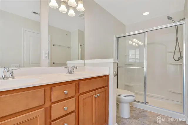 a bathroom with a granite countertop sink a toilet and shower