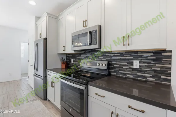 a kitchen with stainless steel appliances granite countertop a sink a stove top oven a counter space and cabinets